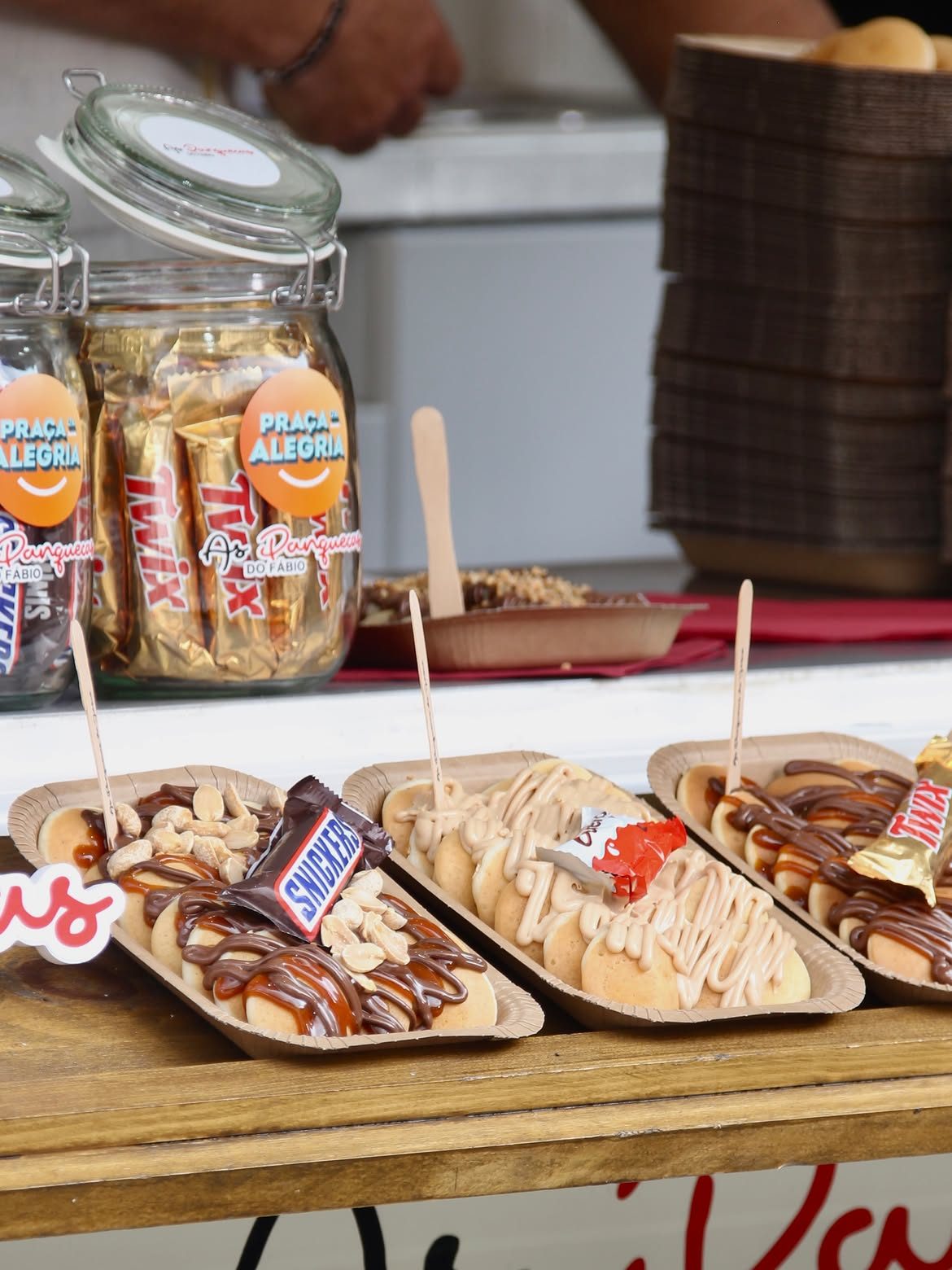 Tabuleiros de mini panquecas com Snickers, Kinder Bueno e Twix, servidos na roulotte